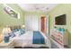 Cozy bedroom with soft green walls, a ceiling fan, and a large window with lush, tropical views at 4245 Corso Venetia Blvd, Venice, FL 34293