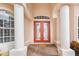 The front entrance has a brick paver entry, stately columns, and a bright red double-door at 4245 Corso Venetia Blvd, Venice, FL 34293
