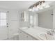 White bathroom features double sinks, a vanity, and a glass enclosed walk-in shower at 4931 Hidden Oaks Trl, Sarasota, FL 34232