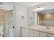 Bright bathroom featuring double sinks, a vanity, and glass enclosed walk-in shower at 4931 Hidden Oaks Trl, Sarasota, FL 34232