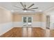 Spacious bedroom features hardwood floors, a ceiling fan, and French doors to the pool at 4931 Hidden Oaks Trl, Sarasota, FL 34232