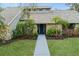 Charming single-story home featuring stone accents, a well-manicured lawn, and lush landscaping at 4931 Hidden Oaks Trl, Sarasota, FL 34232