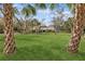 Spacious front yard of this home with mature palm trees at 4931 Hidden Oaks Trl, Sarasota, FL 34232
