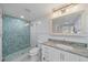 Stylish bathroom showcasing a modern shower with blue tile, elegant fixtures, and ample lighting, perfect for relaxation at 504 Bayview Dr, Holmes Beach, FL 34217