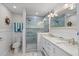 Bathroom boasts a glass-enclosed shower, double vanity with granite countertop, and nautical decorations at 504 Bayview Dr, Holmes Beach, FL 34217