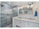 Modern bathroom featuring a double vanity, granite counters, and a glass-enclosed shower with tiled walls at 504 Bayview Dr, Holmes Beach, FL 34217