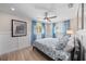 Bright bedroom with a wood plank floor, ceiling fan, and a floral print comforter at 504 Bayview Dr, Holmes Beach, FL 34217
