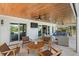 Inviting outdoor living space with a wood plank ceiling, comfortable seating, and an outdoor kitchen at 504 Bayview Dr, Holmes Beach, FL 34217
