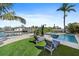 Inviting backyard oasis with a sparkling pool, lounge chairs, and a waterfront view for luxurious relaxation at 504 Bayview Dr, Holmes Beach, FL 34217
