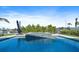 Stunning pool and spa combination surrounded by lush greenery and a tranquil waterfront setting at 504 Bayview Dr, Holmes Beach, FL 34217