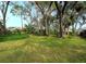 Lush backyard with mature trees and green grass at 5642 Garden Lakes Dr, Bradenton, FL 34203