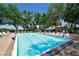 Large community pool surrounded by lounge chairs and mature trees providing shade on a sunny day at 5642 Garden Lakes Dr, Bradenton, FL 34203