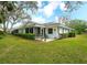Home exterior with lush yard, patio, and a trimmed hedge at 5642 Garden Lakes Dr, Bradenton, FL 34203