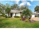 Attractive home with a lush green lawn, decorative foliage, and a welcoming entrance at 5642 Garden Lakes Dr, Bradenton, FL 34203