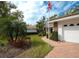 Landscaped front yard with lush greenery and brick pathway leads to a charming home with a two-car garage at 5642 Garden Lakes Dr, Bradenton, FL 34203