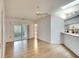 Open floor plan living space features a light wood floor, skylight, and sliding glass doors at 5642 Garden Lakes Dr, Bradenton, FL 34203