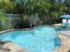 A pristine pool surrounded by lush tropical landscaping and a white privacy fence is perfect for hot days at 5807 De Palmas Ave, Holmes Beach, FL 34217