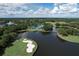 Breathtaking aerial view showcasing the lake, golf course, and beautiful community layout against a sunny, cloudy skyline at 6612 Saint James Xing, University Park, FL 34201