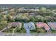 Aerial view of the house with a green roof and a screened-in pool in a verdant neighborhood at 6612 Saint James Xing, University Park, FL 34201