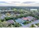 A scenic aerial view showcasing a home nestled among lush greenery, a lake, and a golf course at 6612 Saint James Xing, University Park, FL 34201