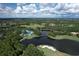 Breathtaking aerial view showcasing the lake, golf course, and beautiful community layout against a sunny, cloudy skyline at 6612 Saint James Xing, University Park, FL 34201
