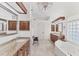 Bright bathroom boasts double vanities, granite countertops, soaking tub, travertine floors and a modern chandelier at 6612 Saint James Xing, University Park, FL 34201