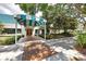 Stunning entrance to the club house featuring a brick pathway, porte-cochere, and beautiful landscaping at 6612 Saint James Xing, University Park, FL 34201