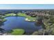 Beautiful aerial view of lush golf course featuring mature trees and a large pristine lake at 6612 Saint James Xing, University Park, FL 34201