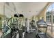 Well-equipped gym features mirrored walls, various machines, and natural light from arched windows at 6612 Saint James Xing, University Park, FL 34201