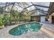 The backyard features a clear-view screened enclosure and pool surrounded by lush landscaping at 6612 Saint James Xing, University Park, FL 34201