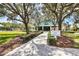 Beautiful tennis and fitness center featuring lush landscaping, a manicured lawn, and a paved walkway at 6612 Saint James Xing, University Park, FL 34201