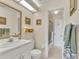 Bright bathroom with elegant vanity, decorative framed mirror and walk-in shower at 6790 Sarasea Cir # 6790, Sarasota, FL 34242