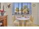 Cozy breakfast nook with a small table, two chairs, and a window overlooking palm trees at 6790 Sarasea Cir # 6790, Sarasota, FL 34242