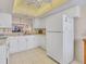 Bright kitchen with white cabinetry and appliances, featuring a pass-through window to the dining area at 6790 Sarasea Cir # 6790, Sarasota, FL 34242