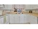 Well-maintained kitchen featuring white cabinets, stainless steel sink, and a view into the living area at 6790 Sarasea Cir # 6790, Sarasota, FL 34242