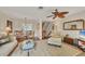 Open-concept living room with dining area and staircase, featuring a ceiling fan and neutral decor at 6790 Sarasea Cir # 6790, Sarasota, FL 34242