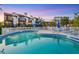 Community pool with lounge chairs and tables, surrounded by a white picket fence and tropical landscaping at 6790 Sarasea Cir # 6790, Sarasota, FL 34242