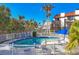Community pool surrounded by a white fence, with lounge chairs and palm trees in the background at 6790 Sarasea Cir # 6790, Sarasota, FL 34242