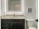 Elegant bathroom vanity with marble countertop, black hardware, and a modern, lighted mirror with electronic touch controls at 1210 Gulf Blvd, Englewood, FL 34223