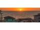 Beautiful sunset over the ocean with beachfront homes in view, showcasing a serene coastal living environment at 1210 Gulf Blvd, Englewood, FL 34223