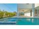 Inviting in-ground pool and spa with covered patio, ceiling fans, and lush, tropical landscaping at 1210 Gulf Blvd, Englewood, FL 34223