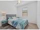 Bright bedroom featuring tiled floors, ceiling fan, and stylish turquoise and white bedding at 2081 Gardenia Ave, Port Charlotte, FL 33953