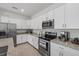 A modern kitchen with stainless steel appliances, granite countertops and white cabinets at 2081 Gardenia Ave, Port Charlotte, FL 33953
