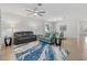 Open-concept living space featuring dual sofas, a ceiling fan, and an adjacent dining area at 2081 Gardenia Ave, Port Charlotte, FL 33953