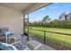 Screened patio with comfortable seating and a view of the lush backyard and green hedge at 2081 Gardenia Ave, Port Charlotte, FL 33953