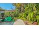 Lush backyard with a green bench and tropical landscaping, perfect for relaxing at 2377 Burton Ln, Sarasota, FL 34239