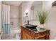 Charming bathroom featuring a vessel sink atop a carved cabinet, with a tub and shower at 2377 Burton Ln, Sarasota, FL 34239