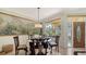 Elegant dining area featuring large scenic wall art, ornate table with glass top, and bright window at 2377 Burton Ln, Sarasota, FL 34239