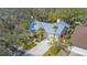 An aerial view of a house with a metal roof, lush landscaping, and a driveway with a walkway to the front door at 2377 Burton Ln, Sarasota, FL 34239