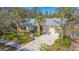 Charming home with a metal roof, a light blue front door, and lush, mature landscaping surrounding the property at 2377 Burton Ln, Sarasota, FL 34239